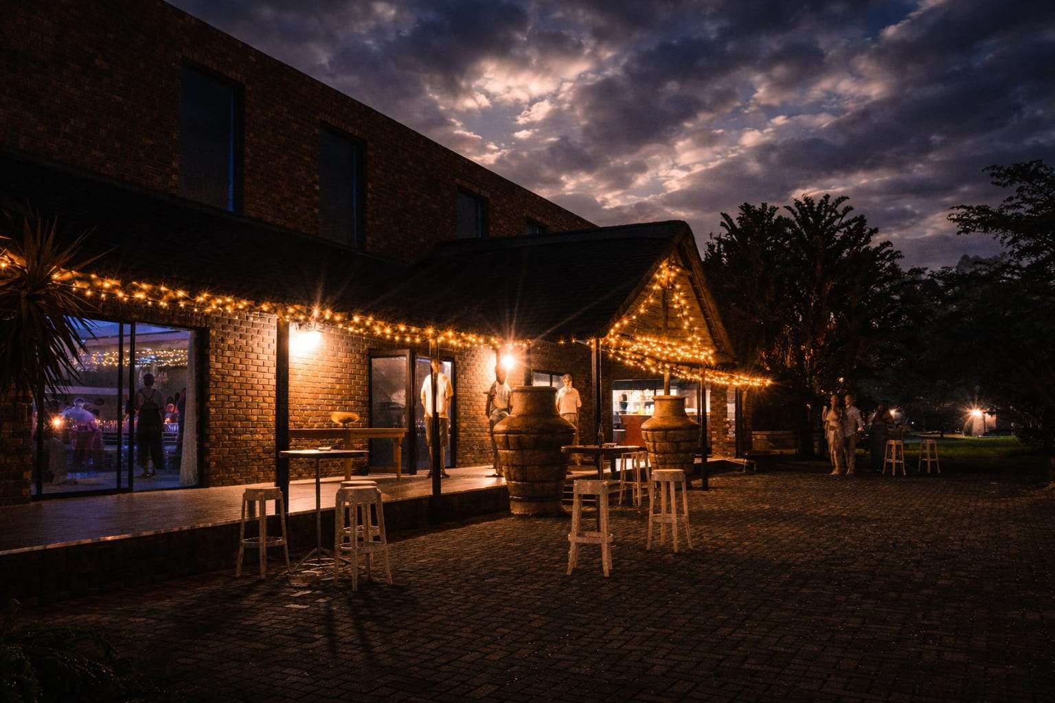 Fairy lights glowing along the thatched stoep of the Main Hall after dark